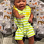 Sawyer is registered to the contest to win money with this photo: baby, infant, smiling, striped_clothing, romper, couch, pillow, animal_pattern, happy, waving, cute, indoor, child, face, feet, hand, sitting, fabric, room, young