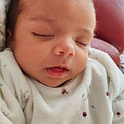 Lisandro a rejoint le concours — aidez-le/la à gagner de superbes lots ! baby, sleeping, infant, onesie, white_clothing, patterned_clothing, animal_print, berry_print, face, head, closed_eyes, soft_texture, red_leather, couch, indoors, cozy, resting, peaceful, newborn, portrait