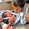Nathan is registered to the contest to win money with this photo: baby, newborn, child, boy, holding, blanket, hospital, bed, hands, love, family, indoor, person, sibling, cute, toddler, sleeping, comfort, warmth, care