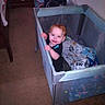 Legend is registered to the contest to win money with this photo: toddler, child, playpen, smiling, indoor, carpet, blanket, furniture, baby, person, happy, standing, room, home, toy, clothing, face, hand, baby_bed, childcare