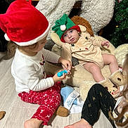 Rita a rejoint le concours — aidez-le/la à gagner de superbes lots ! baby, toddler, child, christmas, holiday, elf_hat, santa_hat, plush_chair, toy, pajamas, floor, playing, indoor, festive, boots, cute, family, fun, happy, cozy
