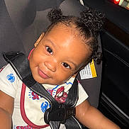Mateo is registered to the contest to win money with this photo: toddler, child, car_seat, seatbelt, smile, curly_hair, hairstyle, clothing, spiderman, indoor, car_interior, cute, happy, portrait, baby, person, black_hair, seat, young_child, safety