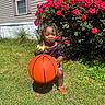 child, toddler, basketball, outdoor, garden, roses, flowers, grass, house, portrait, smiling, braids, beads, dress, sandals, sunlight, sport, ball, nature, playful