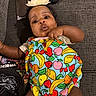 Gianna joined the competition — help win amazing prizes! baby, child, infant, portrait, lying_down, carpet, flower_headband, colorful_clothing, fruit_pattern, onesie, fist, curious, wide_eyes, indoors, floor, baby_bottle, clothing, snack_wrapper, closeup, family_photo