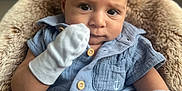 Devon is registered to the contest to win money with this photo: baby, infant, blue_clothing, mittens, cute, portrait, face, child, sitting, furry_cushion, closeup, indoors, cozy, soft_light, young_child, expression, buttoned_shirt, small_hands, comfortable, adorable