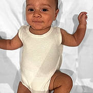 Devon joined the competition — help win amazing prizes! baby, infant, onesie, smile, face, arms, legs, skin, lying_down, blanket, white_clothing, cute, child, happy, portrait, young_child, baby_skin, small_hands, small_feet, indoors