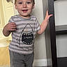 barefoot, carpet, casual_clothing, child, door, floor, furniture, happy, home, indoor, person, portrait, shelf, shirt, shorts, smile, standing, toddler, towel, wall