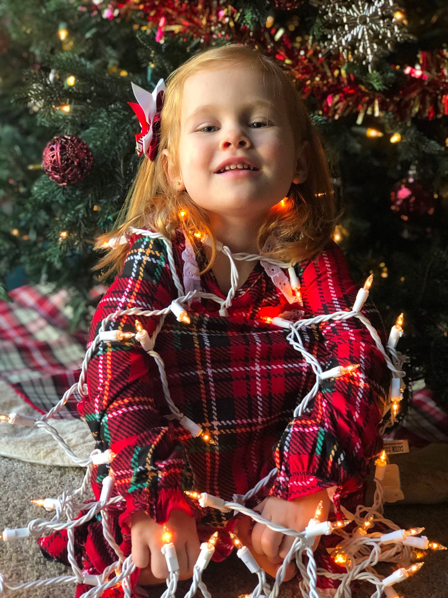 Selah is registered to the contest to win money with this photo: child, child_model, christmas, christmas_decoration, christmas_eve, christmas_ornament, christmas_tree, design, fir, holiday, interior_design, pattern, person, plaid, portrait_photography, smile, tartan, textile, toddler, tradition