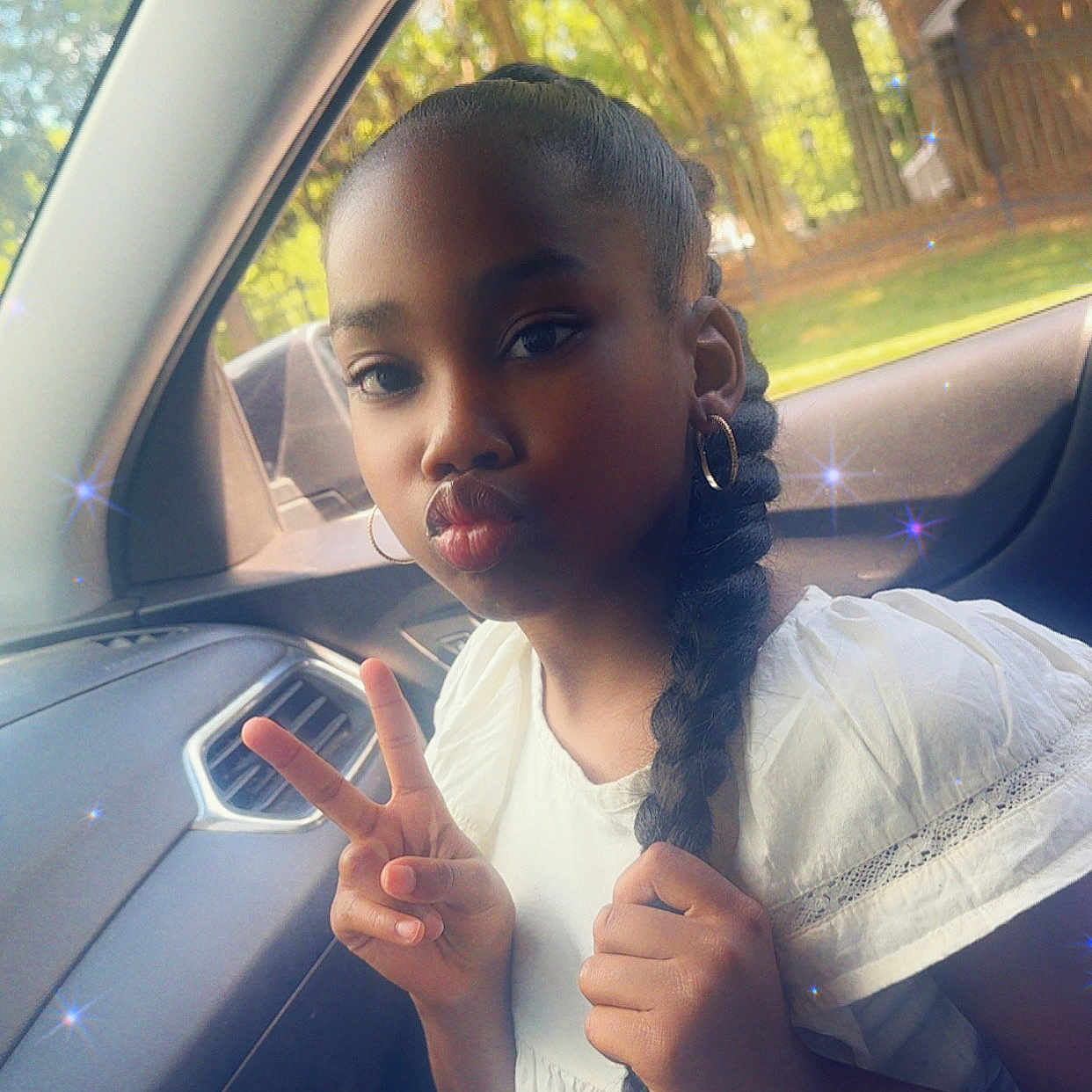 Brooklyn is registered to the contest to win money with this photo: braid, car_interior, casual, child, childhood, cute, daylight, earrings, face, fun, girl, hand_gesture, natural_light, peace_sign, portrait, pouting, sparkles, white_shirt, window, young
