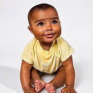 Teddi is registered to the contest to win money with this photo: baby, background, child, closeup, cute, expression, eyes, face, feet, hands, happy, infant, isolated, one_person, portrait, sitting, skin, smiling, studio, yellow_clothing
