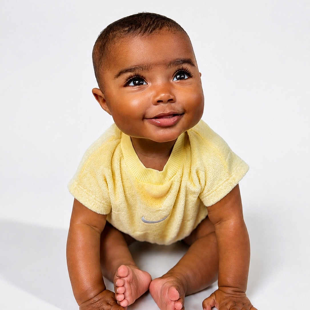 Teddi is registered to the contest to win money with this photo: baby, background, child, closeup, cute, expression, eyes, face, feet, hands, happy, infant, isolated, one_person, portrait, sitting, skin, smiling, studio, yellow_clothing