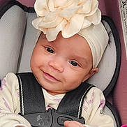Penelope joined the competition — help win amazing prizes! baby, child, headband, flower, car_seat, seatbelt, smile, infant, clothing, blanket, cute, face, person, sitting, indoors, closeup, young, happy, soft, portrait