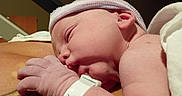 Colton is registered to the contest to win money with this photo: baby, cap, closeup, cute, hospital, hospital_room, human, indoors, infant, newborn, newborn_baby, parent, peaceful, portrait, resting, skin, sleeping, soft_light, tattoo, wristband