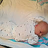 baby, infant, newborn, onesie, whale_pattern, towel, striped_towel, lying_down, soft_texture, cozy, cute, small, sleepwear, child, head, face, skin, blanket, indoors, resting