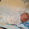 Colton is registered to the contest to win money with this photo: baby, infant, onesie, blanket, sleepwear, newborn, child, cute, soft, lying_down, face, head, clothing, pattern, striped_blanket, cozy, small, indoors, portrait, resting