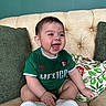 Alexander is registered to the contest to win money with this photo: baby, child, smiling, green_shirt, mexico, sitting, couch, pillows, beige, tufted, happy, indoor, cute, footwear, white_shoes, short_hair, portrait, infant, home, comfortable