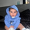 baby, child, hoodie, blue_clothing, mickey_mouse, socks, indoor, bed, blanket, cute, portrait, young_child, sitting, person, face, expression, casual_clothing, cozy, infant, young_baby