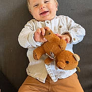 Nelhyö a rejoint le concours — aidez-le/la à gagner de superbes lots ! baby, child, teddy_bear, toy, couch, smile, happy, clothing, shirt, pants, infant, person, indoor, face, hand, furniture, cute, lying_down, striped, cozy