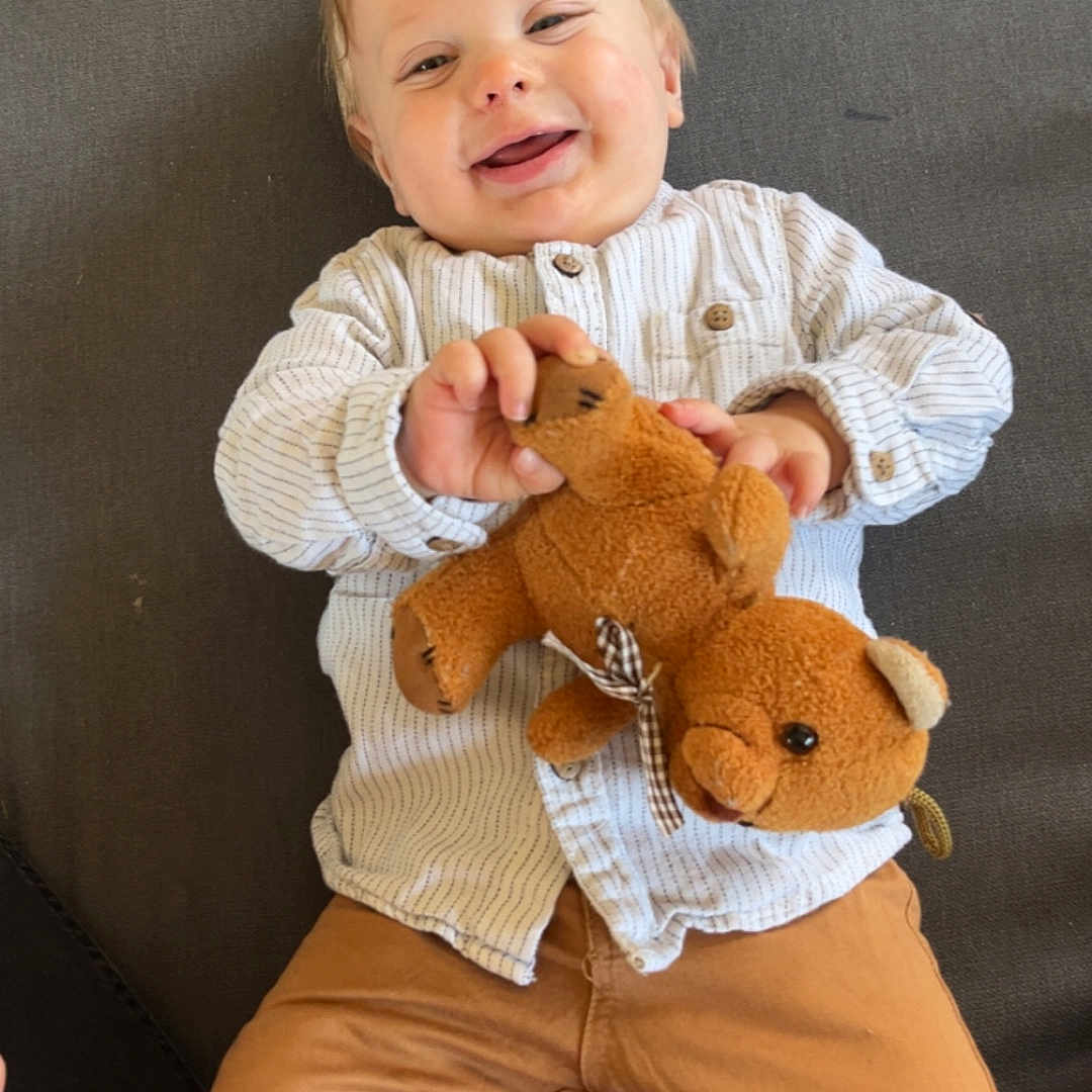 Nelhyö a rejoint le concours — aidez-le/la à gagner de superbes lots ! baby, child, clothing, couch, cozy, cute, face, furniture, hand, happy, indoor, infant, lying_down, pants, person, shirt, smile, striped, teddy_bear, toy