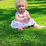 Laikyn is registered to the contest to win money with this photo: baby, barefoot, child, colorful, curly_hair, daylight, dress, fence, garden, grass, greenery, heart_pattern, nature, outdoor, playful, portrait, sitting, summer, sunny_day, toddler