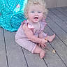 baby, backpack, barefoot, blue_eyes, child, crumbs, curly_hair, cute, daylight, expression, innocence, outdoor, person, pink_outfit, polka_dot, portrait, sitting, snack, turquoise, wooden_deck