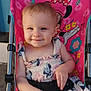 baby, child, smile, stroller, dress, floral_pattern, minnie_mouse, pink, blue, seatbelt, happy, outdoor, person, cute, young_child, sitting, face, head, clothing, toy_character