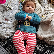 Adem a rejoint le concours — aidez-le/la à gagner de superbes lots ! baby, belt_design, blue_top, child, comfortable, cozy, cushion, cute, fabric, face, head, indoor, infant, lying_down, pacifier, patterned_blanket, portrait, soft_toys, striped_pants, young_child