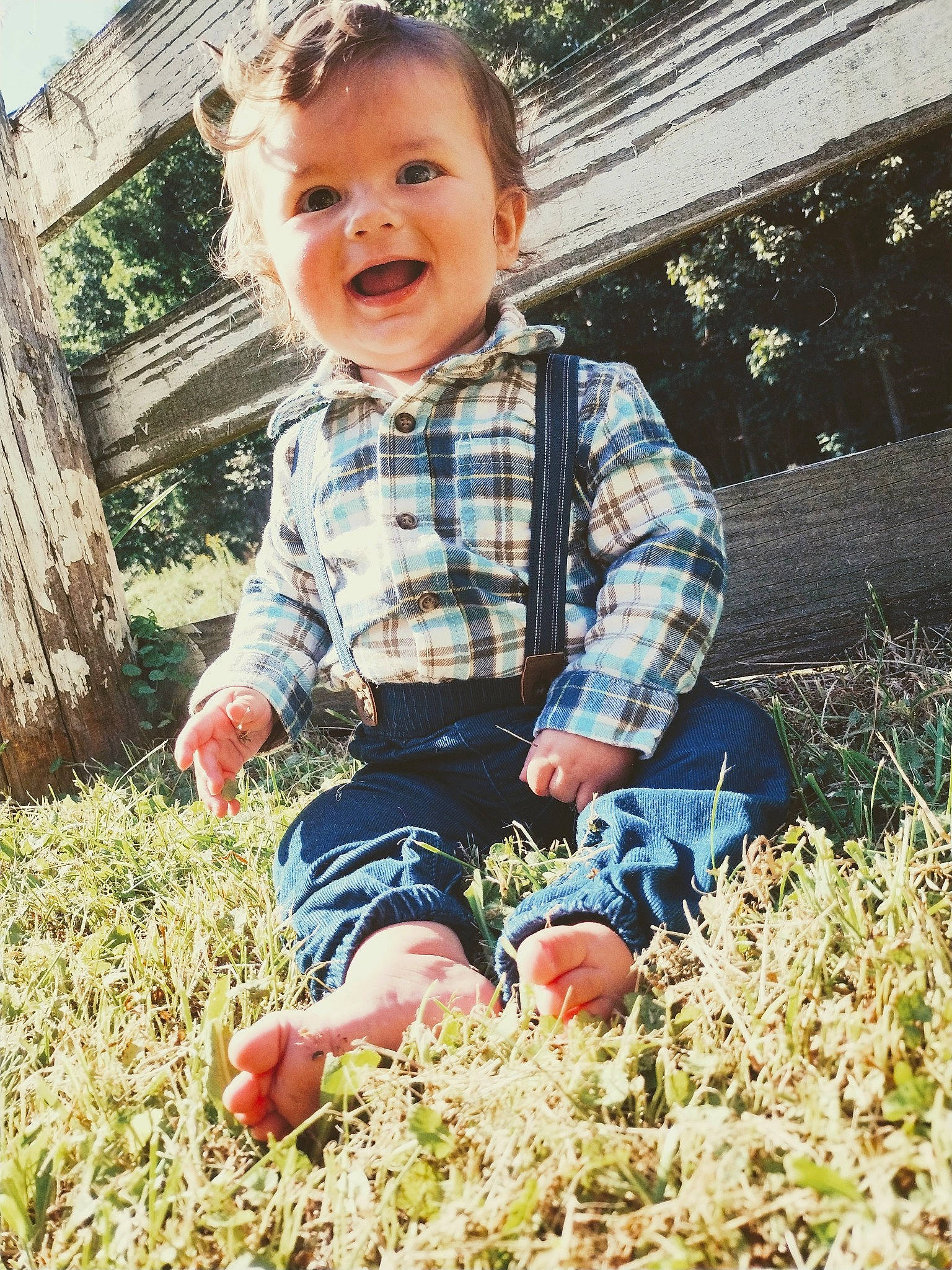 Brannan is registered to the contest to win money with this photo: baby_toddler_clothing, child, denim, eye, fun, grass, grass_family, happy, head, leaf, people_in_nature, person, photograph, plaid, plant, sitting, sleeve, smile, t_shirt, tartan