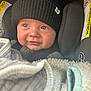baby, child, car_seat, hat, black_hat, blanket, cozy, smile, face, eyes, clothing, infant, cute, portrait, indoor, seatbelt, warm, headwear, person, young