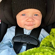 Jaxon joined the competition — help win amazing prizes! baby, child, car_seat, black_hat, blue_clothing, blanket, green_blanket, harness, seatbelt, infant, face, portrait, cute, indoor, child_seat, knit_hat, looking_at_camera, baby_clothes, young_child, close_up