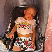 Xyaire is registered to the contest to win money with this photo: black, casual, child, clothing, curly_hair, eyelashes, face, graco, hand, outdoor, pink_skin, racecar, resting, shorts, sleeping, stroller, sunlight, toddler, tshirt, water_bottle