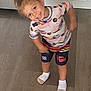 cabinet, casual_wear, child, colorful_clothing, cute, happy, home, indoor, kitchen, motion_blur, person, playful, pony_tail, portrait, shorts, smiling, socks, standing, wooden_floor, young_child