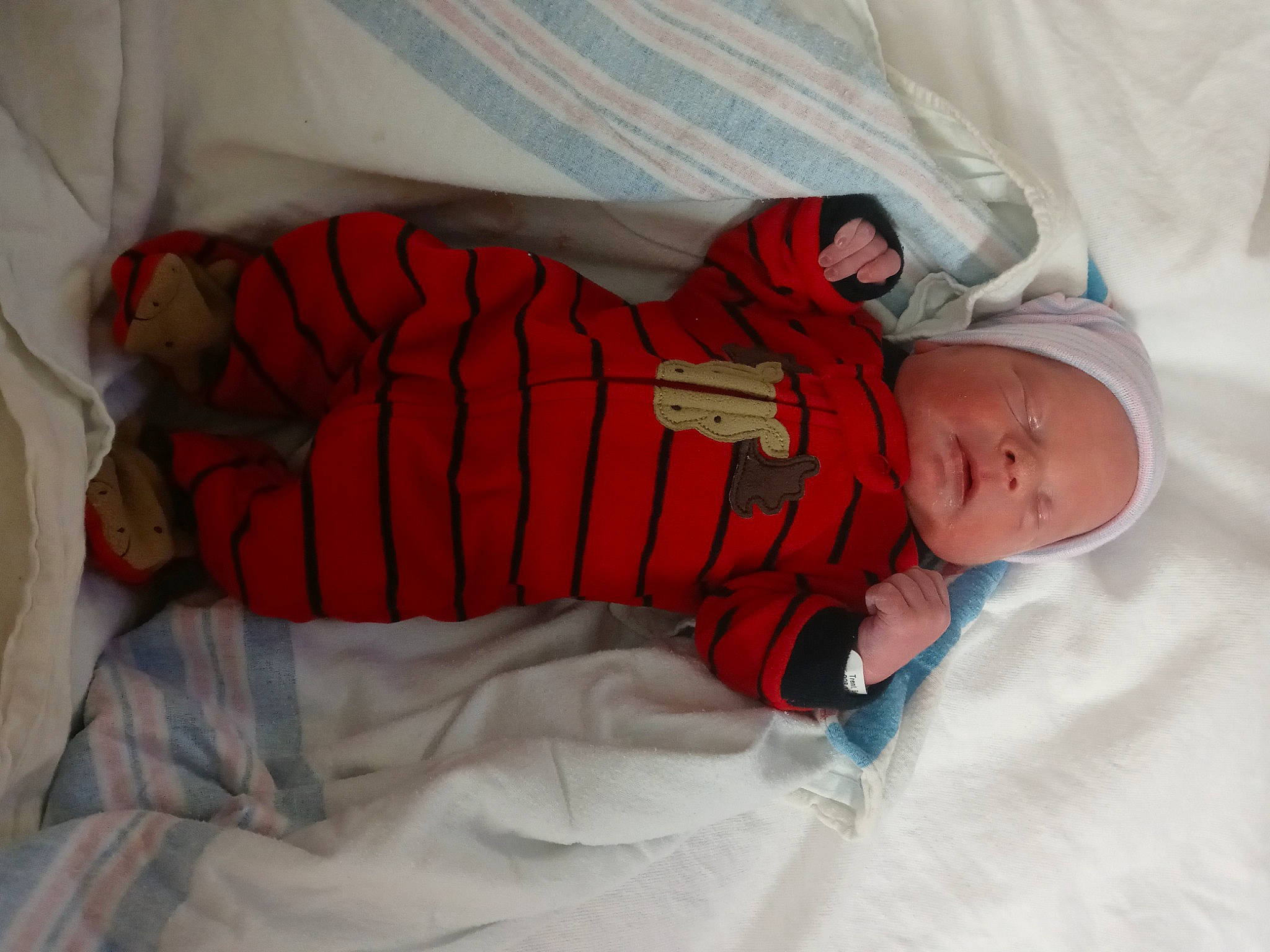 Axl is registered to the contest to win money with this photo: baby, baby_products, baby_sleeping, baby_toddler_clothing, bedding, bedtime, carmine, child, comfort, hat, human_body, linens, nap, orange, pattern, person, room, sleeve, sock, toddler