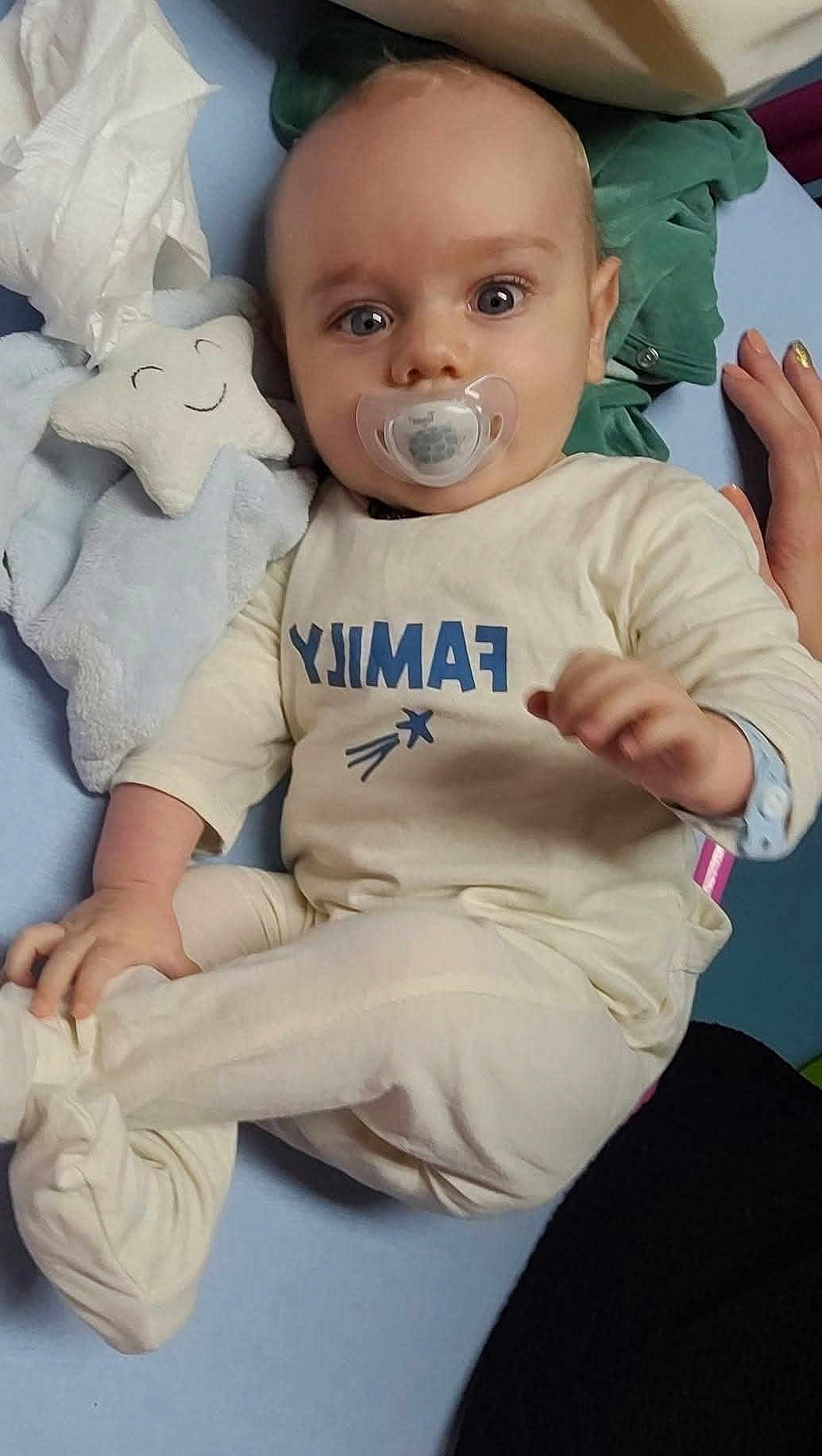 Sacha a rejoint le concours — aidez-le/la à gagner de superbes lots ! baby, infant, pacifier, plush_toy, star_shaped_toy, blanket, clothing, hand, lying_down, cute, child, soft_toy, bed, comfort, sleepwear, smile, face, person, indoor, cozy