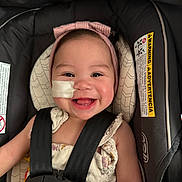 Sophia Wodrich is registered to the contest to win money with this photo: baby, child, smiling, headband, car_seat, seatbelt, medical_tape, cute, happy, infant, face, portrait, clothing, safety, indoor, closeup, person, seat, baby_girl, adorable