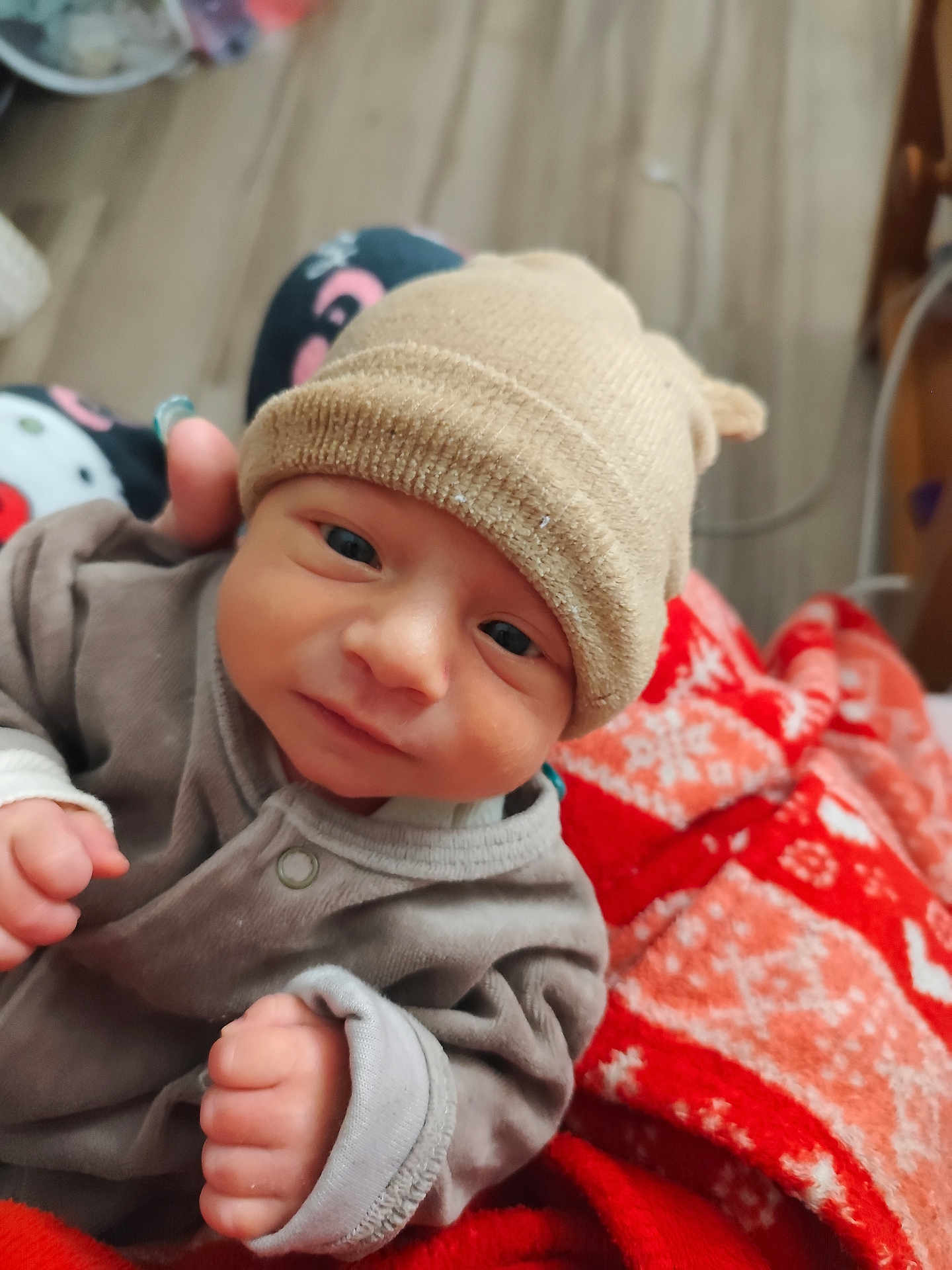 Swayn a rejoint le concours — aidez-le/la à gagner de superbes lots ! baby, infant, hat, clothing, blanket, fist, face, person, cute, cozy, indoor, newborn, portrait, child, warm, soft, expression, young, sitting, apparel