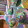 Arthur a rejoint le concours — aidez-le/la à gagner de superbes lots ! toddler, child, disco_balls, reflection, neon_lights, colorful, sparkle, curious, indoor, lights, mirror, face, hand, sweater, cute, playful, decor, bright, young_child, glitter