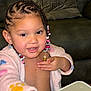 toddler, child, braided_hair, beads, robe, indoor, couch, cushion, table, play, smile, face, hand, person, young_child, skin, furniture, living_room, cute, expression