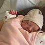 Emy participe au concours pour gagner de l'argent avec cette photo : baby, newborn, sleeping, pink_clothing, hat, hand, face, indoor, bed, pajamas, peaceful, cozy, blanket, person, infant, soft_lighting, cute, resting, child, closeup