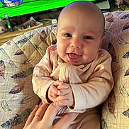 Ivey joined the competition — help win amazing prizes! baby, smiling, infant, hand, finger, cushion, feather_pattern, television, cartoon, indoor, person, clothing, happy, face, head, sitting, closeup, skin, child, cute