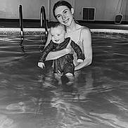 Remi is registered to the contest to win money with this photo: baby, black_and_white, child, face, family, fun, happy, holding, indoor, joy, person, pool, portrait, reflection, relaxation, smile, swimsuit, together, water, woman