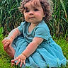 toddler, child, baby, curly_hair, blue_dress, outdoor, grass, field, plants, portrait, sitting, face, smiling, long_hair, barefoot, nature, greenery, daylight, photography, cute