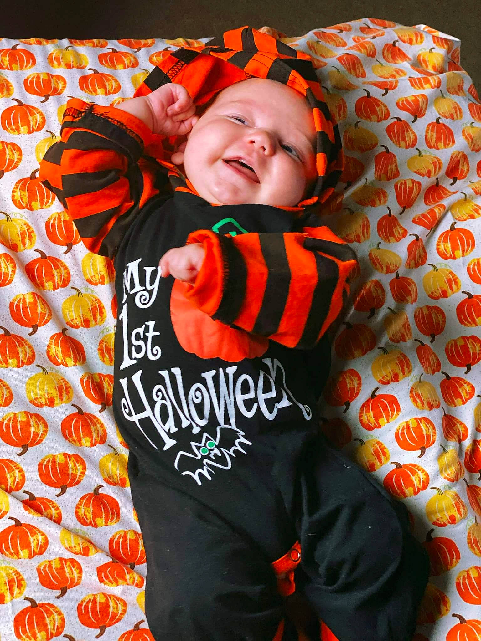 Booker is registered to the contest to win money with this photo: baby, baby_products, baby_toddler_clothing, child, comfort, face, facial_expression, font, fun, happy, linens, orange, outerwear, pattern, peach, person, sleeve, smile, t_shirt, textile