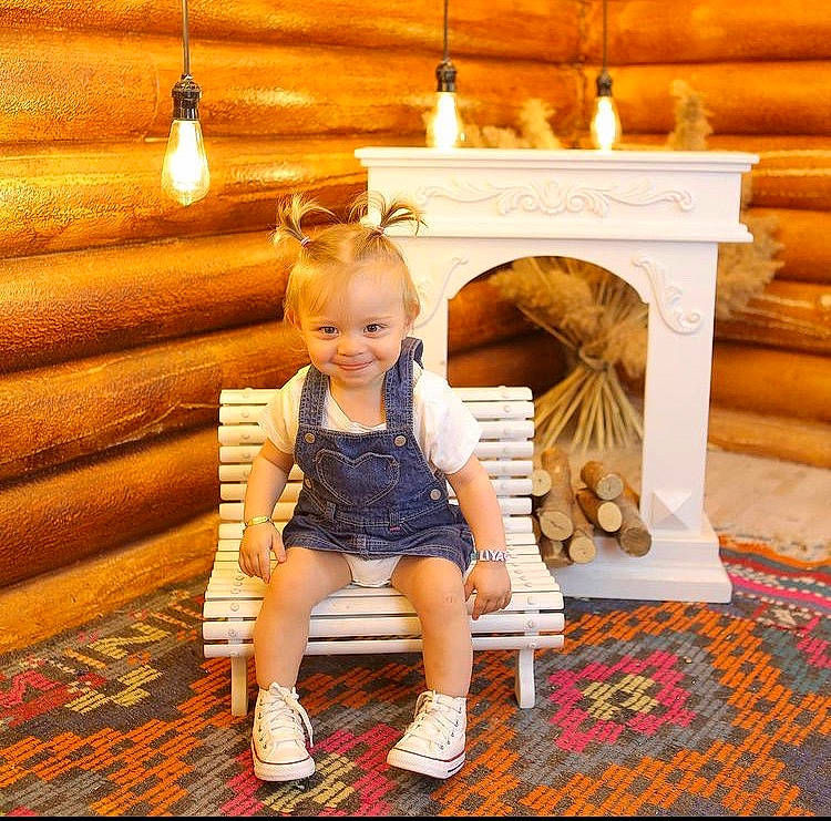 Liya a rejoint le concours — aidez-le/la à gagner de superbes lots ! arch, child, floor, flooring, fun, happy, hardwood, hearth, human_leg, joy, leisure, orange, peach, person, room, sitting, smile, toddler, toy, wood