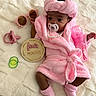 Lauryn joined the competition — help win amazing prizes! baby, infant, pink_robe, headband, pacifier, baby_bottle, socks, blanket, sunglasses, milestone_plaque, pearl_necklace, cute, soft_texture, lying_down, indoors, newborn, child, accessories, portrait, cozy