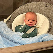 Ezra is registered to the contest to win money with this photo: baby, baby_bouncer, blanket, blanket_texture, blue_blanket, bouncer, cute, expression, face, frown, indoor, infant, newborn, onesie, pacifier, plush, portrait, seat, snug, strap