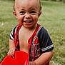 toddler, child, smiling, red_chair, outdoor, grass, happy, boy, short_hair, casual_clothing, portrait, daylight, cute, playful, person, young_child, summer, nature, fun, holding_object