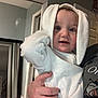 Myles joined the competition — help win amazing prizes! baby, child, hoodie, white_clothing, indoor, person, hand, face, blue_eyes, curious, cute, bunny_ears, adult_hand, mirror, door, home, floor, wall, portrait, holding