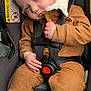 baby, child, car_seat, seat_belt, brown_clothing, corduroy, infant, sleepy, blue_eyes, cute, toddler, safety_harness, indoor, person, young_child, head, hand, foot, warning_label, protectplus