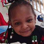 Shavena is registered to the contest to win money with this photo: child, smiling, beads, hair, blanket, indoor, staircase, grinch, christmas, decoration, earrings, person, holiday, festive, home, portrait, cute, happy, cozy, black_clothing